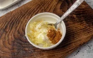 For salad dressing, mix sour cream, chopped garlic, salt and black pepper.