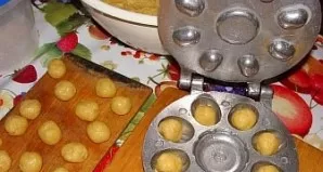 We heat the nut baking sheet on the stove, anoint the cells for the shells with oil. Remove small pieces of dough and put in a mold. We c...