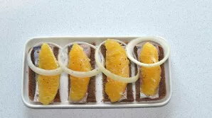 Put a slice of orange on top, put a slice of onion in it and sprinkle with ground pepper.