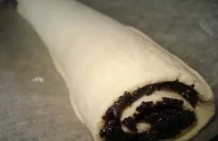 Line the baking sheet with baking paper and grease it a little with butter. Carefully roll up the roll, pressing it and put it on a bakin...