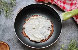 Grease each pancake with cottage cheese filling and roll it into a tube.