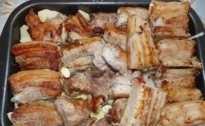 Grease the baking sheet with vegetable oil and put the ingredients in it in layers: 1) fried potatoes 2) onions with garlic 3) ribs coate...