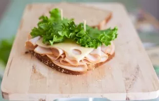 We put a slice of cheese on top of the sausage, put a salad leaf on top and fix the sandwich with toothpicks or wooden skewers.