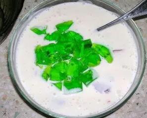 Gradually add crushed jelly to the sour cream-gelatin mixture. Stir.