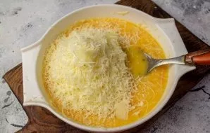 Grate the cheese on a fine grater, add to the mixture of eggs and milk. Stir.