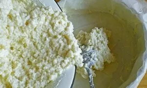 Line the baking sheet with baking paper and grease with butter. Put half of the curd-rice mixture in the form.