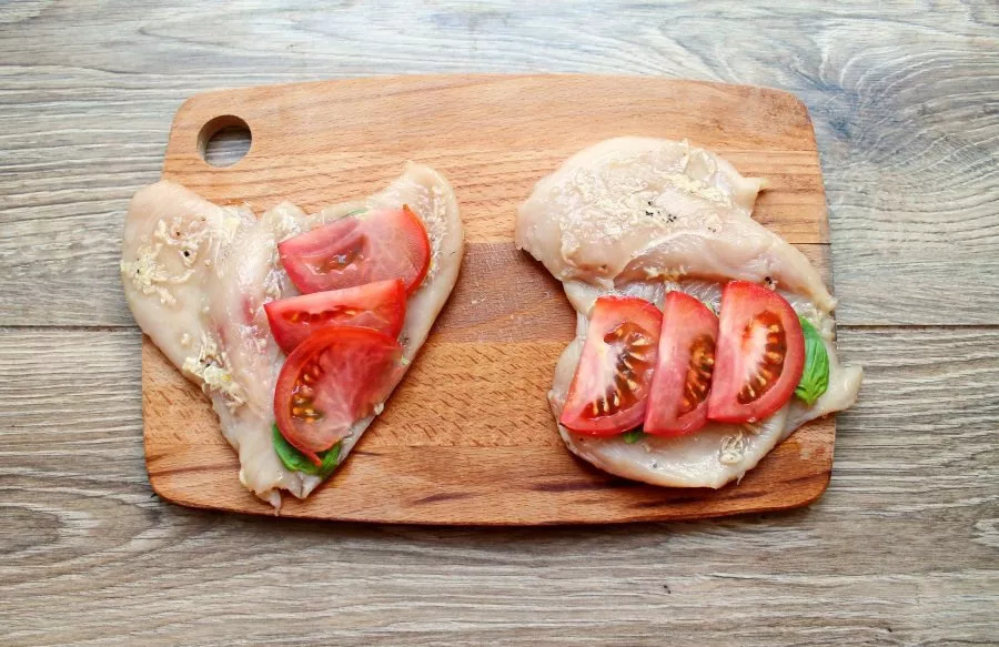 Cut the tomato into slices and arrange on top of the basil.