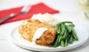 Serve the chicken with sauce, lay out the beans and mashed potatoes next to it. Enjoy your meal!