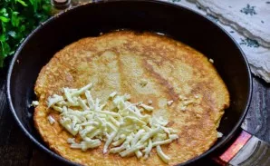 Grate the cheese and put it on the edge of the pancake.