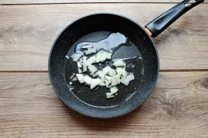 Peel and chop the onion. Pour vegetable oil into the pan and add chopped onion.