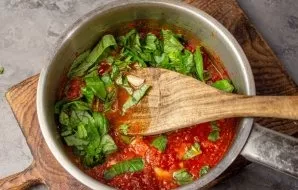 Add prepared herbs, garlic and chilli peppers to the sauce. Boil for a couple of minutes so that their taste is absorbed into the sauce.