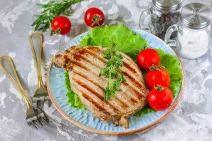 Serve steaks from the electric barbecue with vegetables and herbs, you can add any sauce to the dish.