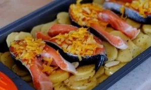 Place carrots and onions on top of the fish, which we will finely chop (we will grate the carrots) and lightly fry.