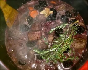 Now you can return the meat to the pan and put prunes. Pour a little red wine. Add a little salt and pepper to taste. Add rosemary, bay l...