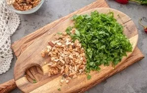 Cut the walnuts into small pieces, finely chop the greens.