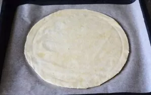 Roll out the risen dough with a thin layer in the form of a circle. I got a circle of dough with a diameter of 30 cm.