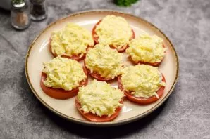 Put a spoonful of cheese filling on each tomato. Serve the snack immediately to the table.
