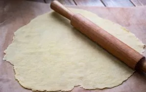 Remove the dough from the refrigerator. To make it easier to roll, divide the entire mass of dough into several parts. Roll out each part...