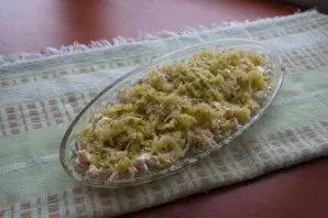 Add a layer of grated cucumber. Pour more mayonnaise on top.