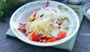 Add grated cheese and pickled onions to the salad.