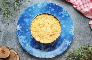 Peel the boiled eggs and separate them into whites and yolks. Crush the yolks with a fork and put on a layer of carrots with a good press.