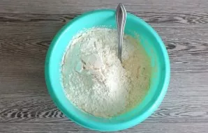 Add flour. Mix the dough well with a spoon.