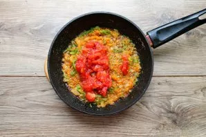 Remove the cuticle from the canned tomatoes, chop and add to the vegetables. While stirring, fry for another 5-7 minutes.