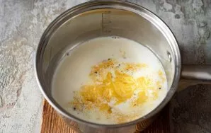 In a saucepan, heat the cream without boiling. Remove the pot with hot cream from the stove and add the egg-cheese mixture to it.