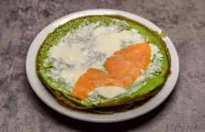Grease the pancakes with cream cheese, and put a piece of salmon on the edge.