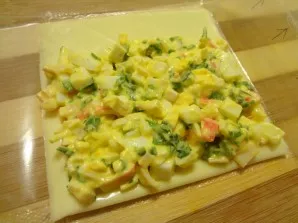 Remove a piece of cheese from the package and carefully distribute a small amount of lettuce on the surface.