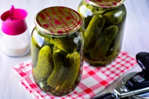 Roll up the jars of cucumbers with iron lids, turn them upside down and cover.
