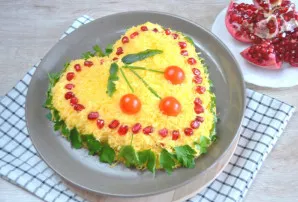 Sprinkle the salad with grated cheese. Garnish with pomegranate seeds and herbs. Make a cherry on top with cherry tomatoes and sprigs of ...