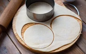 Sprinkle the working surface with flour, roll out the dough with a thin (about 1 mm thick) layer and cut out circles from the dough with ...