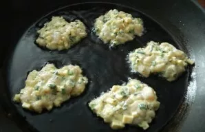 Use a spoon to place the dough in a well-heated pan with vegetable oil.
