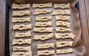 In the rectangles of the dough, make small cuts and turn one part through the hole, forming a juggernaut. Put all the jars in a baking sh...