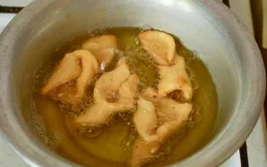 Turn one edge through the hole. Heat vegetable oil, agarella and fry until golden brown.