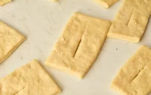 Roll out the dough into a layer, cut out rectangles. In each center make an incision.