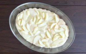 Take a baking dish. Line the bottom with baking paper. Pour 1/2 part of the dough into the mold. Spread the apples on top.