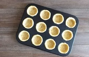 Spread the dough on the sides and bottom of the mold. Pierce the bottom several times with a fork. Place the form with future cupcakes in...