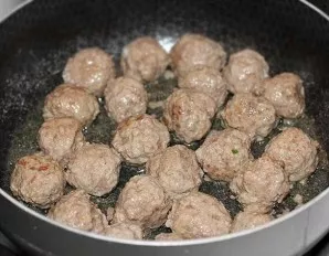 In a separate frying pan over high heat, fry the meatballs until a crust is formed. Pour the tomato paste into the sauce and mix everythi...