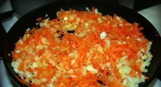 Add carrots to the onion and continue frying.