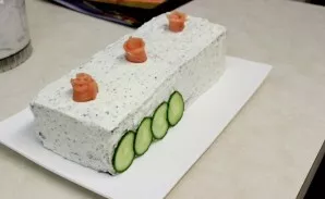 Lay out cucumber slices on the base of the cake. You can also decorate by forming roses from pieces of salmon, as shown in the photo.