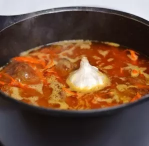 When the water heats up well (not yet boiling), add the head of garlic. Cook on medium heat for 1 hour. Wash the rice.