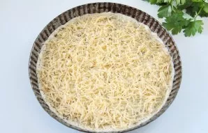 First, grate the harder cheese and sprinkle on top of the pizza.