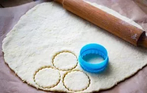 Then lightly sprinkle the work surface with flour and roll out the dough on it with a layer of about 3-4 mm. To cut out the blanks of fut...