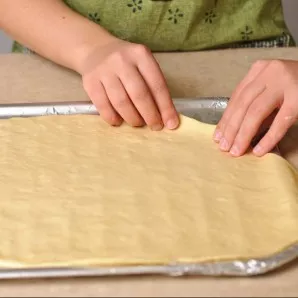 Use a rolling pin to roll out the dough into a thin base.