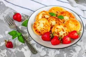 Put the baked curds on plates, decorate to taste and serve warm with fresh berries or sour cream.