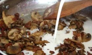 With regular stirring, pour in the cream and milk.