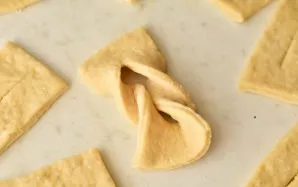 Carefully pierce one end of the dough through the hole.