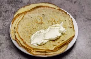 Grease each pancake with curd cream.